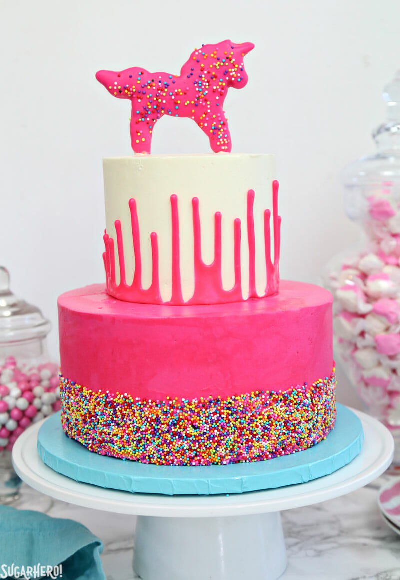 Circus Animal Layer Cake - two-layered cake with a pink sprinkled base layer and white cake decorated with an upside-down ganache drip | From SugarHero.com