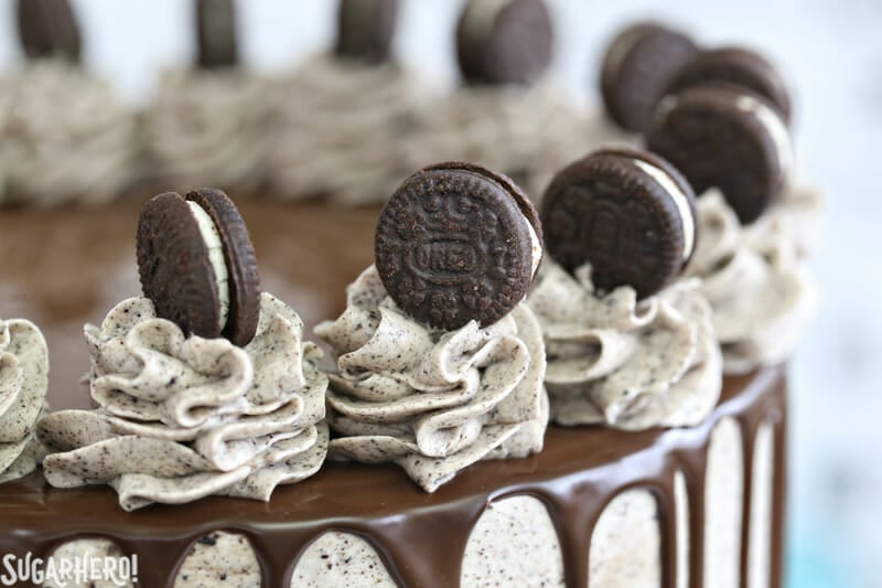 Cookies and Cream Cake - this epic cookies and cream layer cake will satisfy ALL of your chocolate cravings! It has rich devil's food cake plus buttercream with lots of cookie crumbs mixed right in. | From SugarHero.com Cookies and Cream Cake - close-up of mini Oreo cookies on top of the cake | From SugarHero.com
