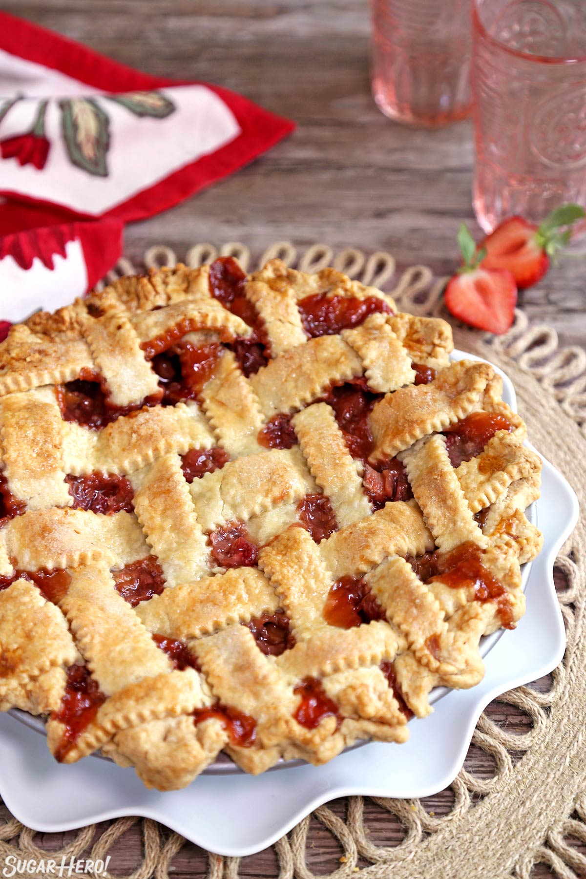 Strawberry Rhubarb Pie - lattice-topped pie on a plate | From SugarHero.com