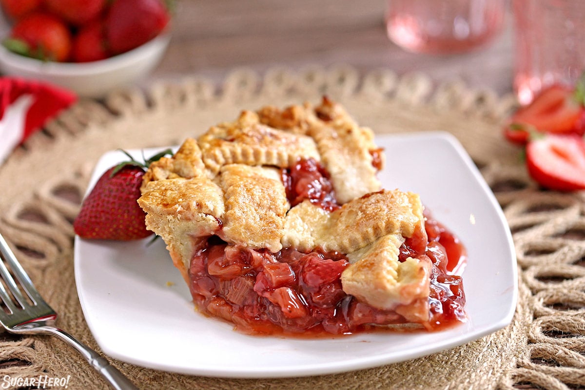 Strawberry Rhubarb Pie is a summertime classic! A flaky, buttery crust is filled with the perfect combination of sweet, juicy strawberries and tart rhubarb. | From SugarHero.com Strawberry Rhubarb Pie - single slice of pie on a plate | From SugarHero.com