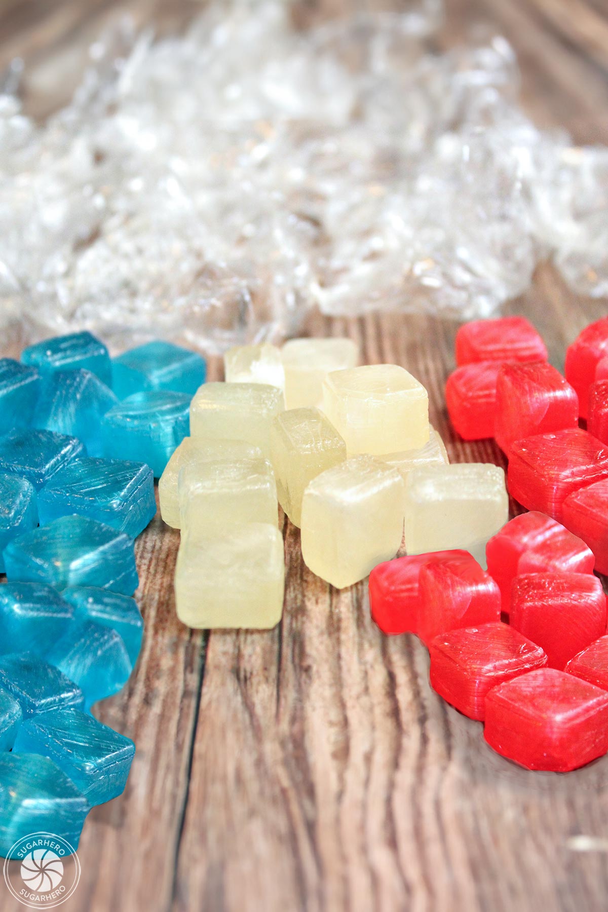 Easy Homemade Lollipops - piles of red, white, and blue hard candies, unwrapped and ready to be made into lollipops | From SugarHero.com