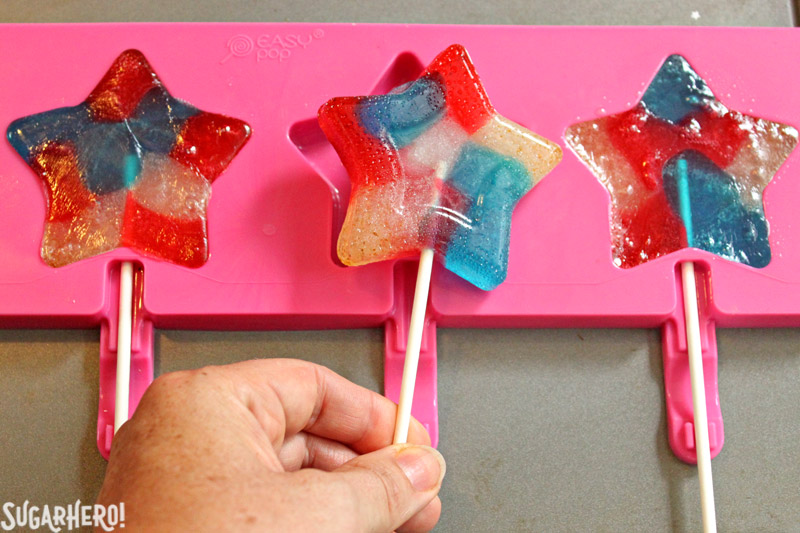 Easy Homemade Lollipops - removing red, white, and blue star-shaped lollipop from candy mold | From SugarHero.com