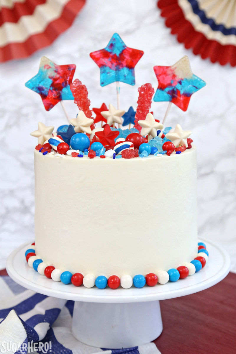 Fourth of July Layer Cake - tall layer cake with red, white, and blue candies on top | From SugarHero.com 