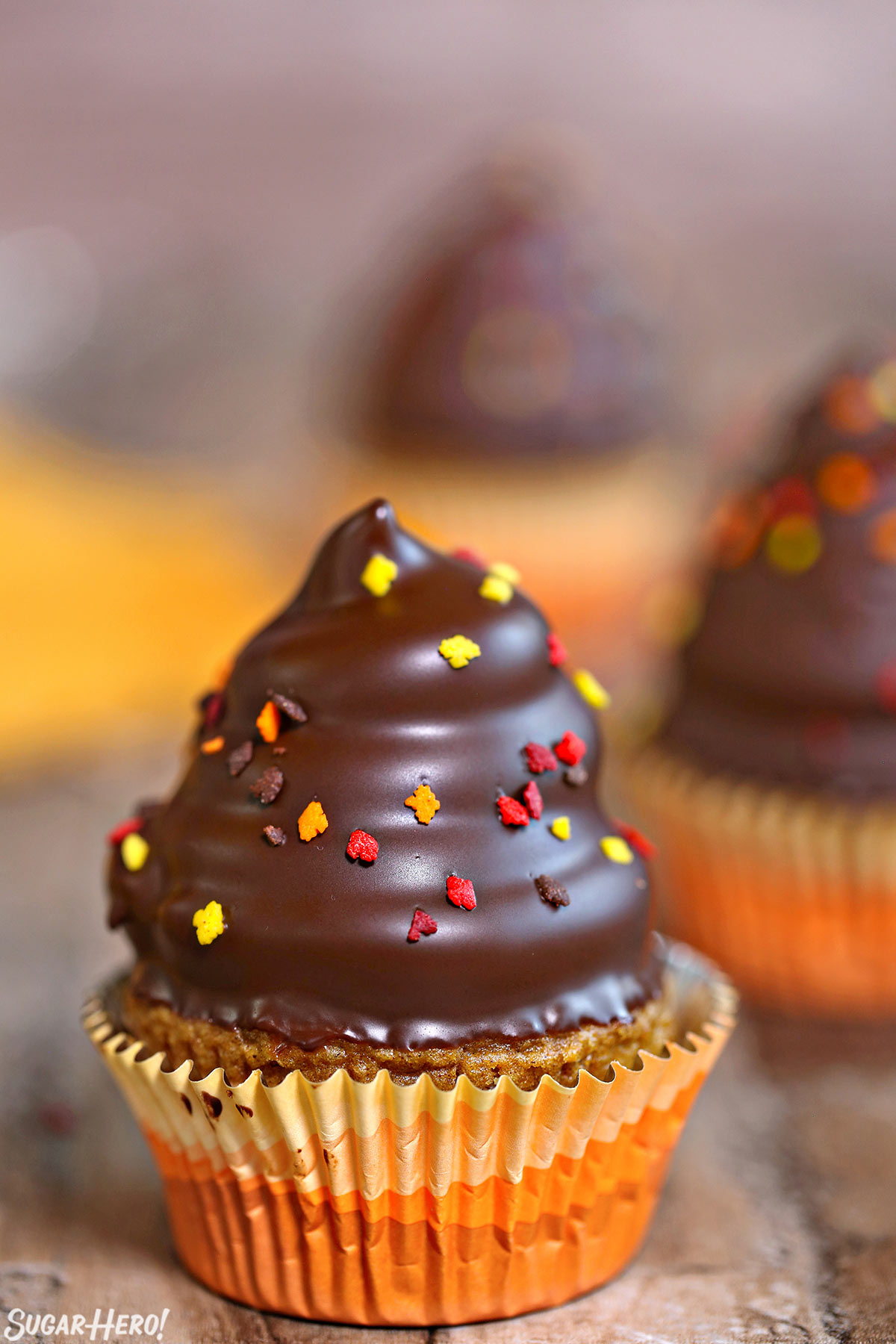 Pumpkin Spice Hi-Hat Cupcakes - Straight shot of a a hi-hat cupcake with sprinkles on top. | From SugarHero.com