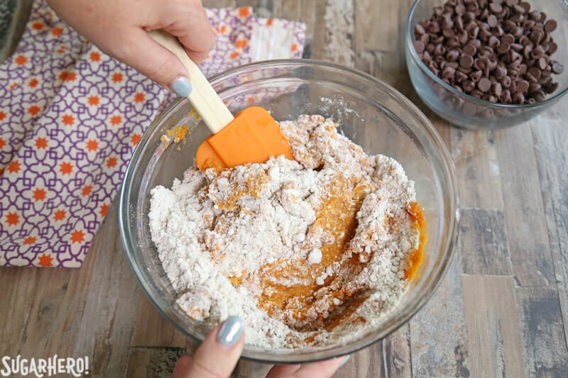 3-Ingredient Pumpkin Chocolate Chip Cookies are a super fast fall dessert! These cookies are made with 3 common pantry ingredients and the whole family is guaranteed to love them! | From SugarHero.com 3-Ingredient Pumpkin Chocolate Chip Cookies - stirring together the cake mix and pumpkin puree | From SugarHero.com
