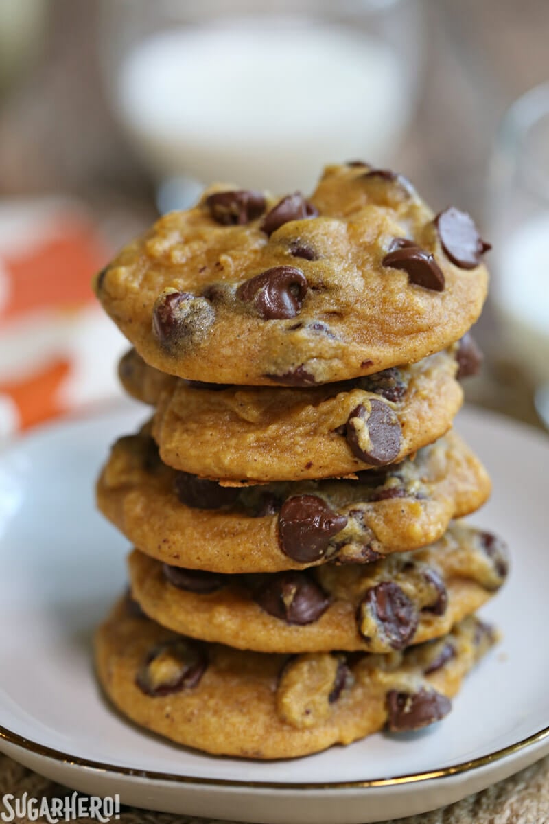 Pumpkin Chocolate Chip Cookies - Regular chocolate chip cookies get a fall makeover with the addition of pumpkin puree and pumpkin pie spices. They're seriously good! | From SugarHero.com Pumpkin Chocolate Chip Cookies - vertical stack of pumpkin chocolate chip cookies on a plate | From SugarHero.com