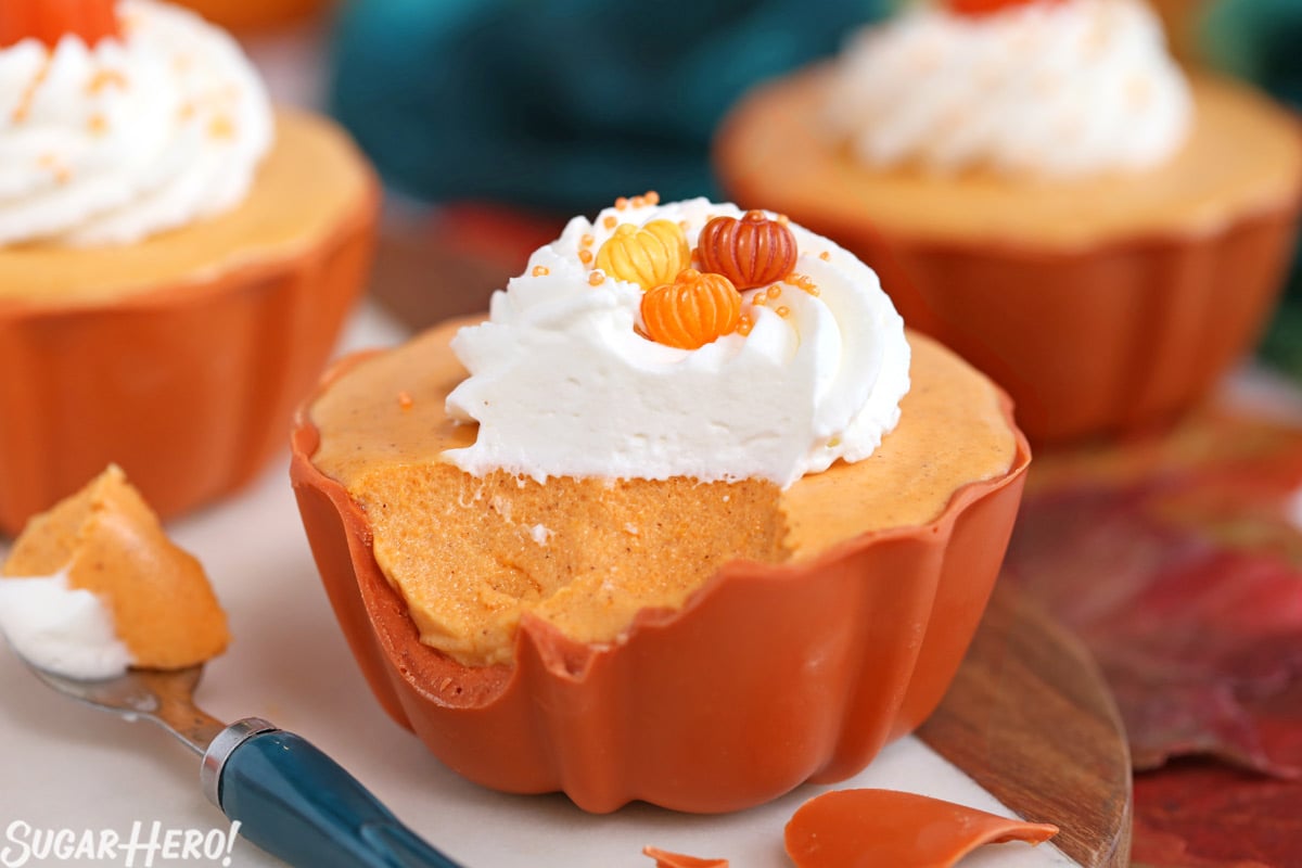 Pumpkin Spice Mousse Cups - This light and fluffy mousse is packed with fall flavor and made with real pumpkin, for an authentic pumpkin spice taste. It’s served in a cute edible candy bowl too! | From SugarHero.com Pumpkin Spice Mousse Cups - mousse up with a bite taken out and some of the edible candy bowl eaten | From SugarHero.com