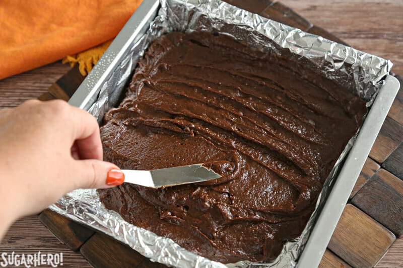 2-Ingredient Pumpkin Brownies - smoothing the pumpkin brownie batter into an even layer in a pan | From SugarHero.com
