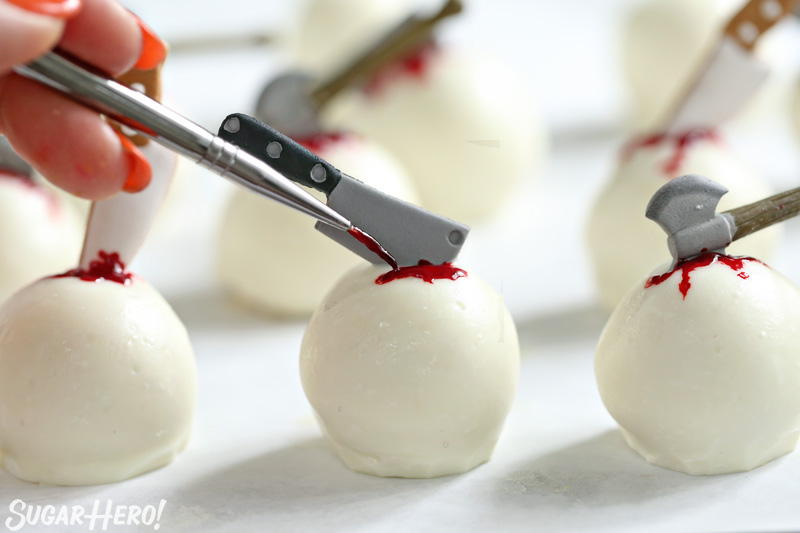 Bloody Truffles - using a paintbrush to paint red gel food coloring on a truffle to look like blood | From SugarHero.com