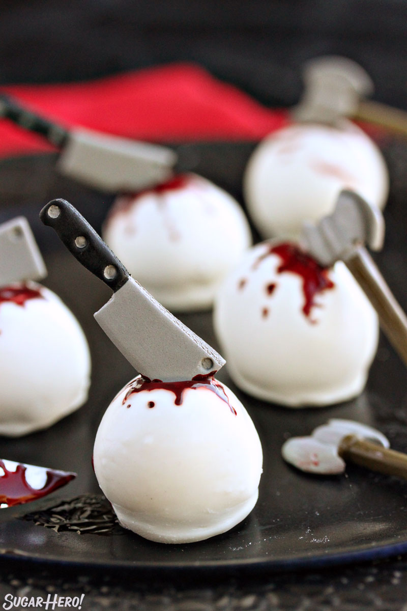 Bloody Truffles - group of bloody truffles with candy weapons on a black plate | From SugarHero.com