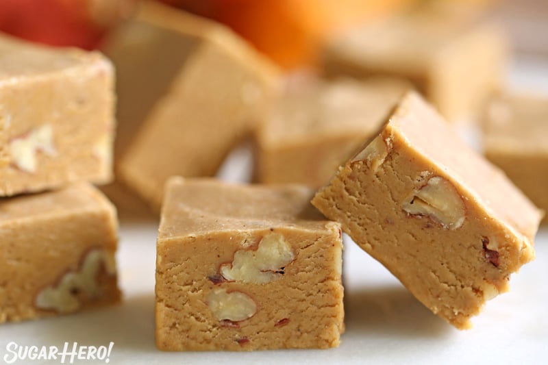 A close up of some pieces of pumpkin fudge with pecans