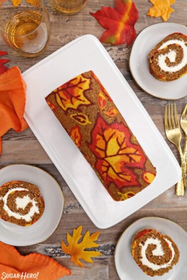 Overhead shot of patterned pumpkin roll with slices displayed around.
