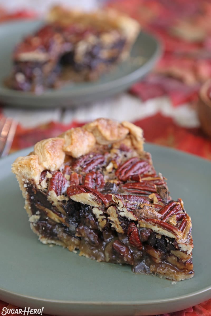 Deep Dish Pecan Pie - slice of deep dish pie on a green plate with another slice in the background | From SugarHero.com