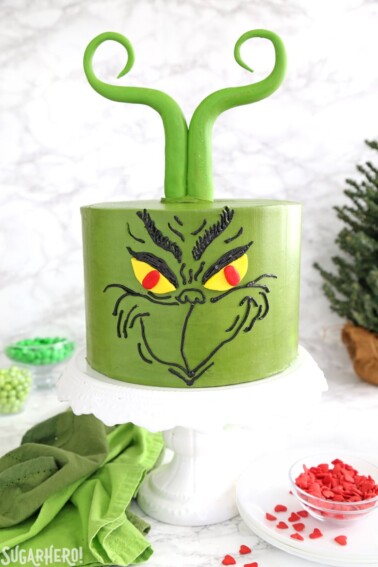 The front of a Grinch Cake on a white cake plate.