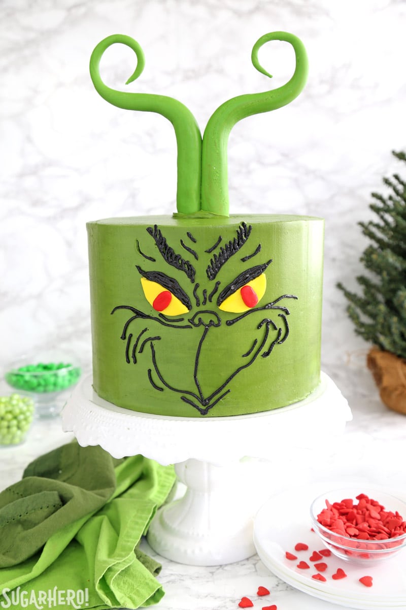 Grinch Cake - green cake decorated with a Grinch's face and fondant Grinch-like hair | From SugarHero.com