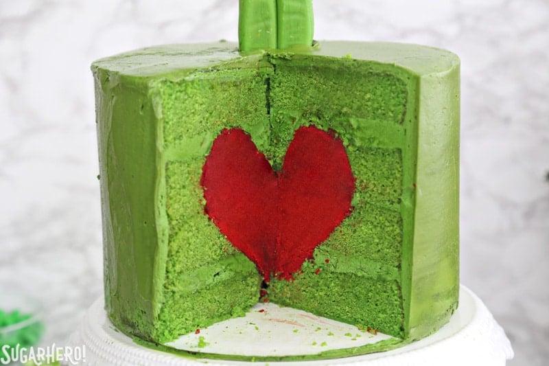 Grinch Cake - close-up of the inside of the green Grinch cake, containing a bright red cake heart | From SugarHero.com