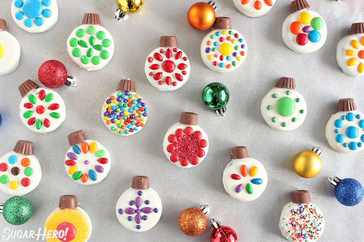 Overhead shot of colorful Oreo Cookie Christmas Ornaments on a silver background.