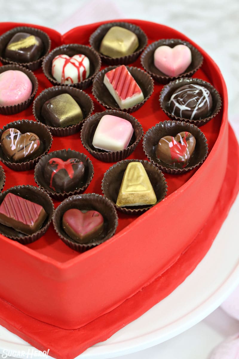 Box of Chocolates Cake - vertical close-up of the top of the cake with chocolates on top | From SugarHero.com