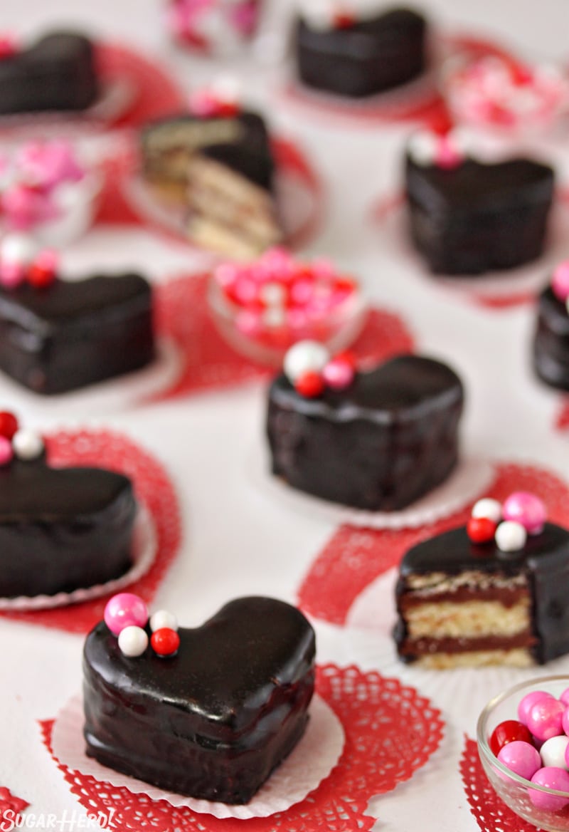 Nutella Pound Cake Petit Fours have big flavor in a small package! These sweet heart-shaped desserts are perfect for Valentine's Day or any special occasion. | From SugarHero.com Nutella Pound Cake Petit Fours - Nutella heart shaped cakes with bowls of candy in between. | From SugarHero.com