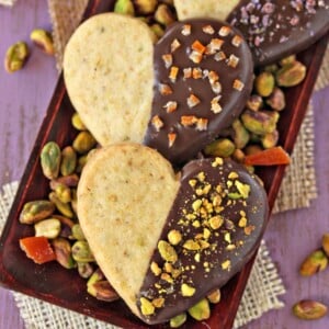 Close up of 2 Pistachio Shortbread Cookies on a tray covered with pistachios.