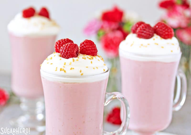 Raspberry White Hot Chocolate - Three separate glasses of hot chocolate and raspberries on top | From SugarHero.com 