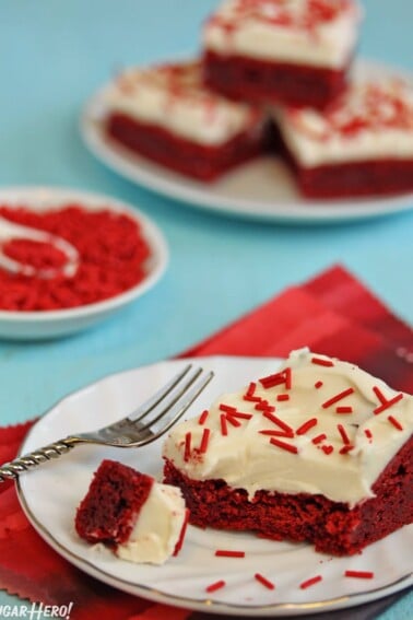 Red Velvet Bar on a white plate with a bite removed next to a silver fork.