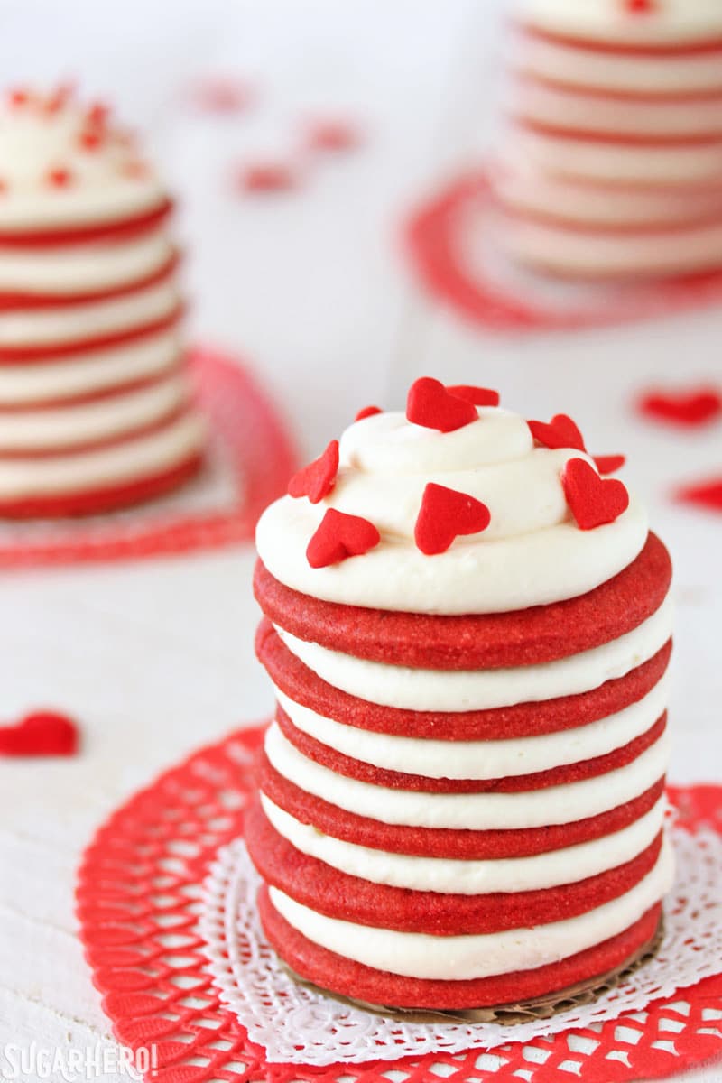Red Velvet Icebox Cakes - A Icebox cake with heart sprinkles and two in the background | From SugarHero.com 