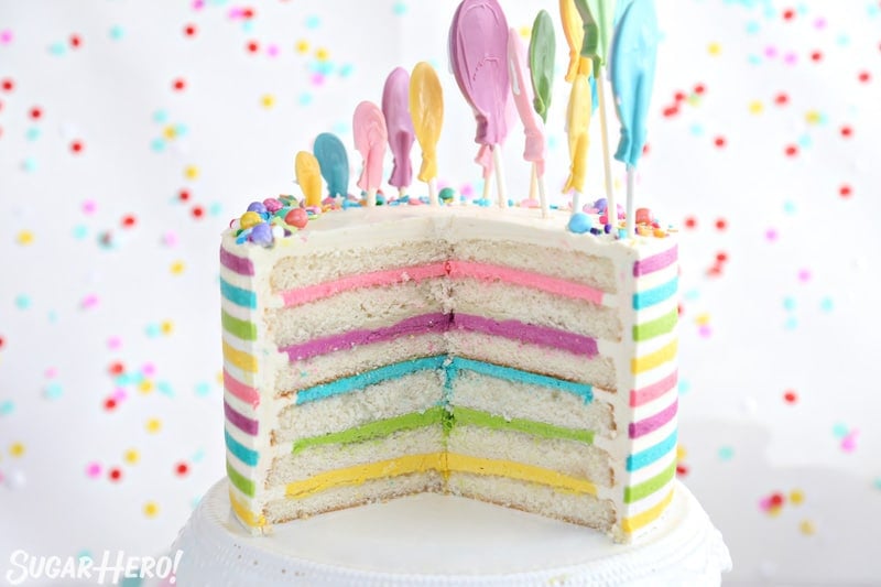 Striped Buttercream cake cut open to reveal multi-colored buttercream layers on the inside.