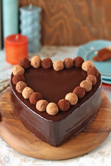A heart-shaped chocolate cake with a ring of truffles around the outside.