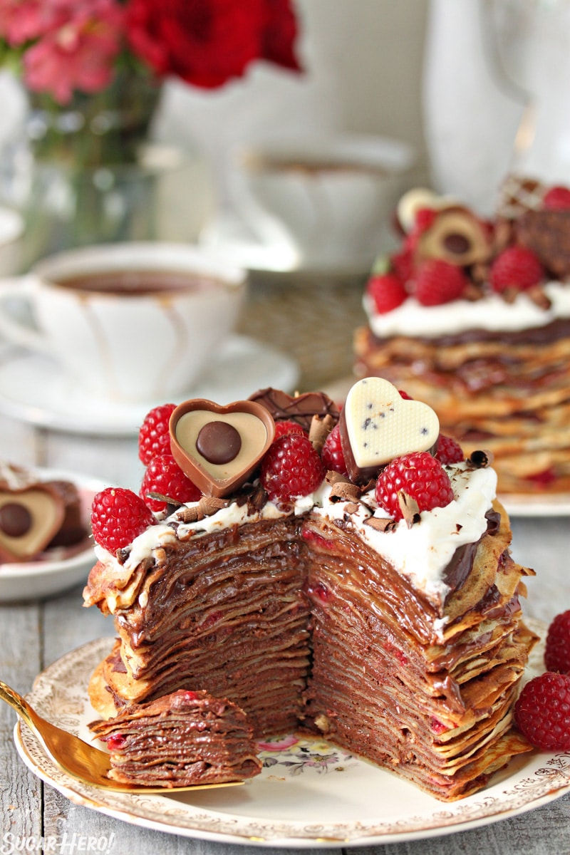Chocolate Raspberry Mini Crepe Cakes - A single crepe cake with a slice taken out showing the inside of the cake. | From SugarHero.com