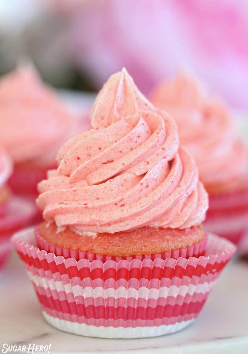 This Strawberry Buttercream is incredible! With a smooth, creamy texture and bright fresh strawberry flavor, it's going to be your new favorite frosting to put on everything! | From SugarHero.com Strawberry Buttercream Frosting - cupcake decorated with a big swirl of strawberry frosting | From SugarHero.com