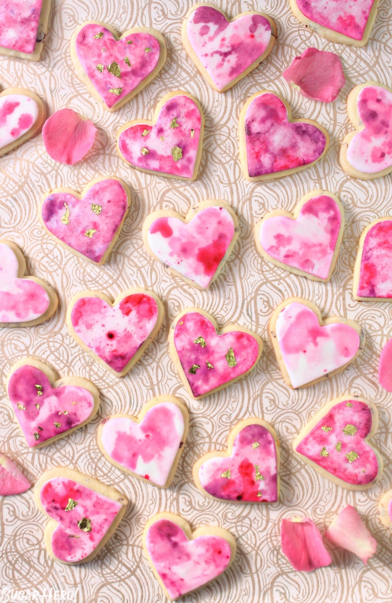 Watercolor Rose Sugar Cookies - Multiple cookies displayed with rose petals throughout. | From SugarHero.com 