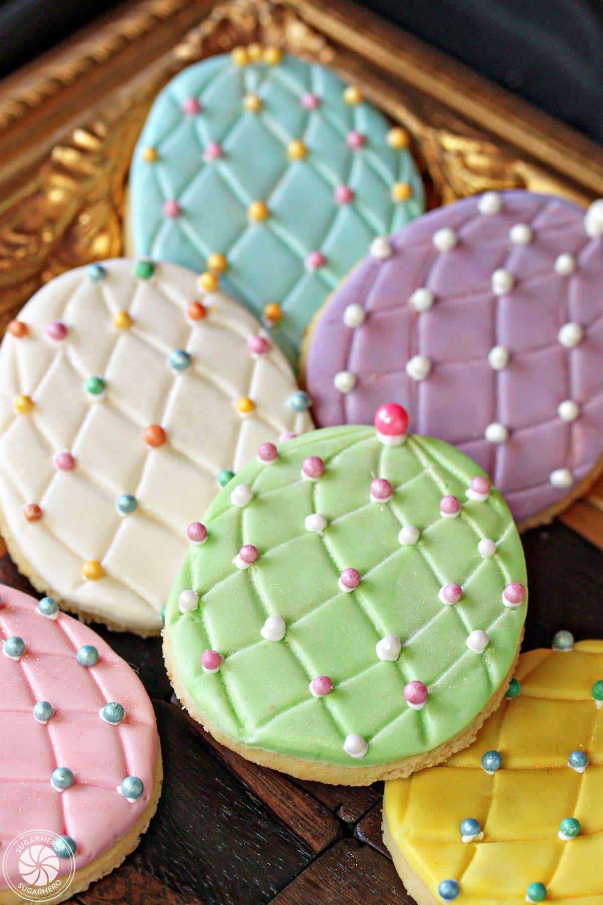 Easter Egg Sugar Cookies with colorful sugar pearl accents on a gold tray