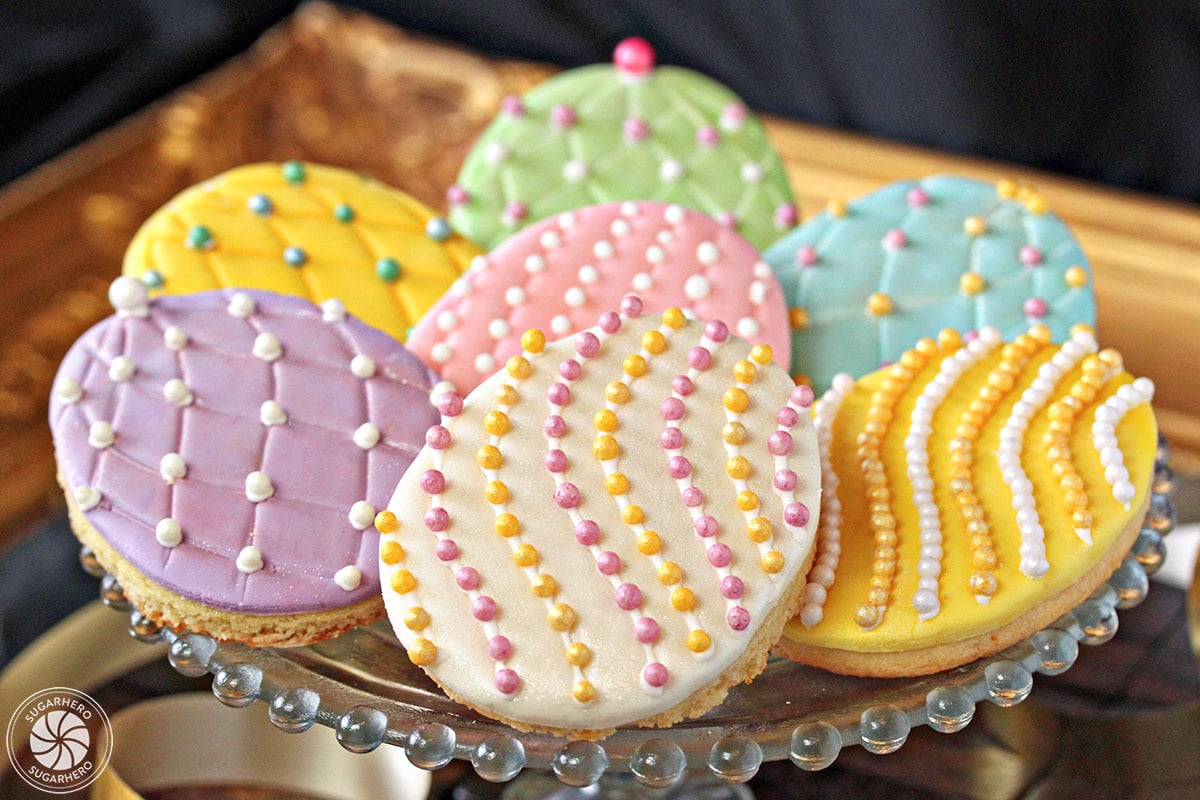 Easter egg sugar cookies on a gold tray with colorful sugar pearls