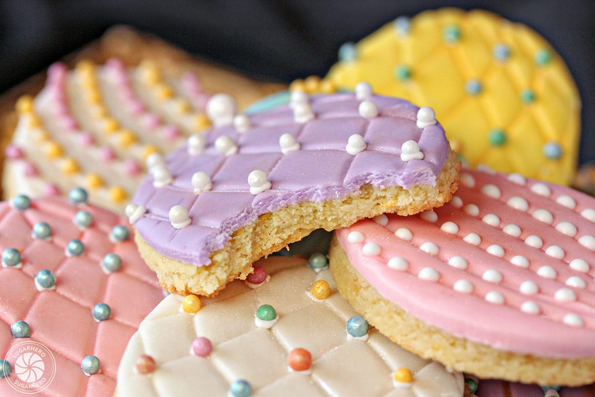 Close-up of sugar cookie with purple fondant, and a bite taken out of it