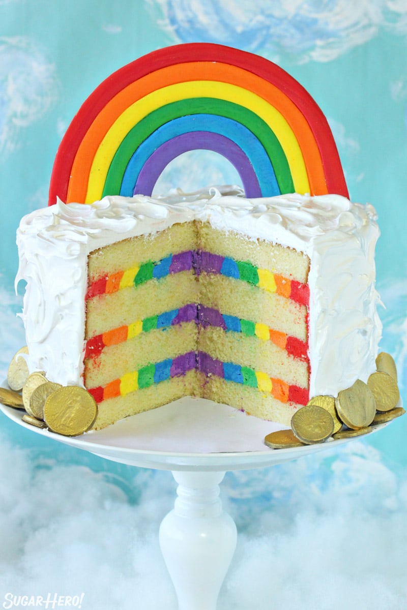 Cut open view of rainbow cake, with a fondant rainbow and rainbow frosting inside
