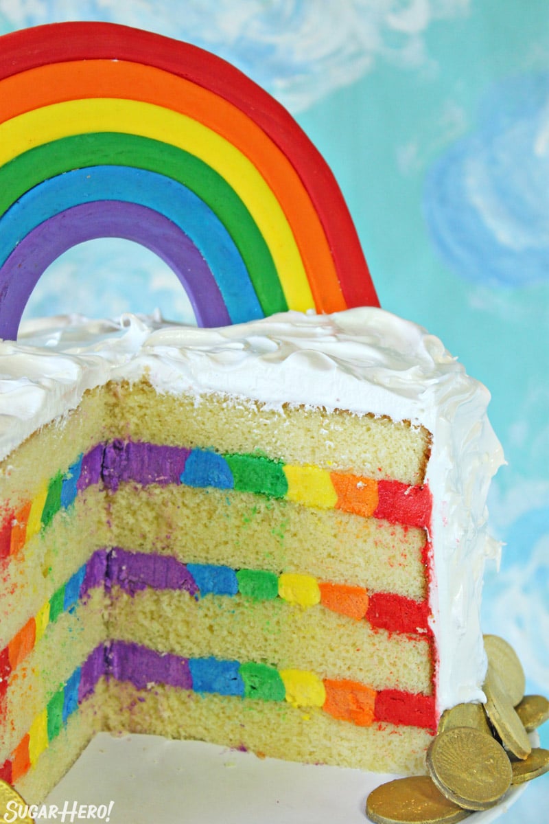 Rainbow cake cut open with rainbow frosting inside