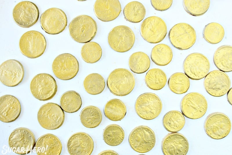 Edible chocolate gold coins on white surface