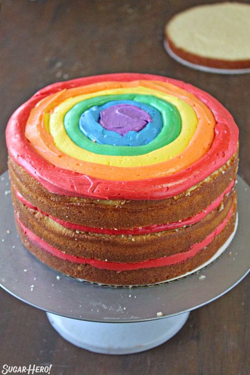 Rainbow cake during assembly, showing rings of rainbow frosting inside