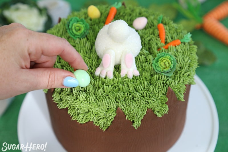 Placing a chocolate egg on top of the Chocolate Easter Bunny Cake