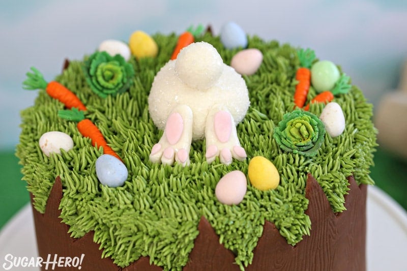 Close-up of the top of the Chocolate Easter Bunny Cake, with a fondant bunny butt and fondant carrots and cabbages