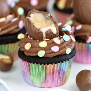 A Chocolate Crème Egg Cupcake in a rainbow wrapper.