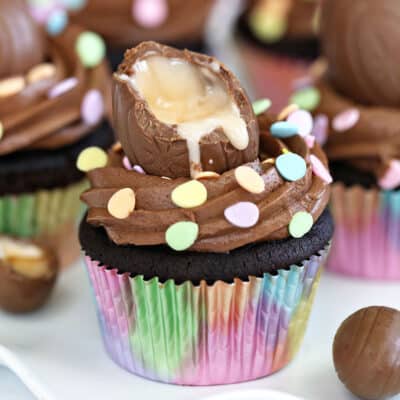 A Chocolate Crème Egg Cupcake in a rainbow wrapper.