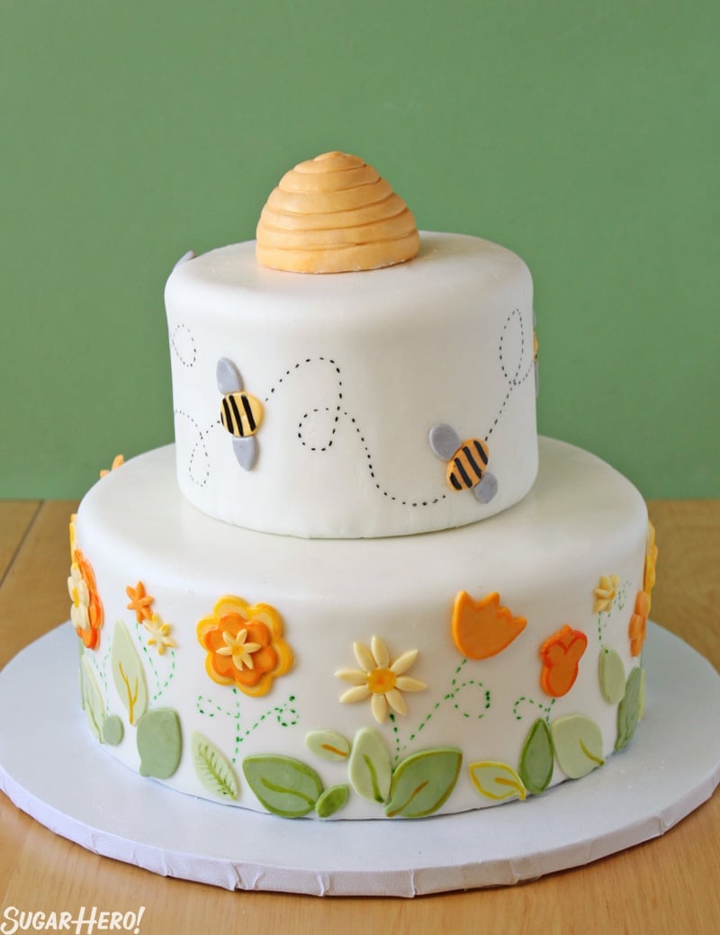 Bumblebee Cake - A shot of the full layer cake with a beehive on top made of fondant.  | From SugarHero.com 