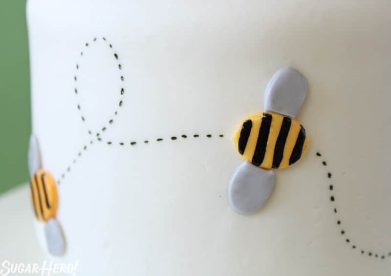 Bumblebee Cake - A close up shot of a bee made of fondant with a black trail. | From SugarHero.com 