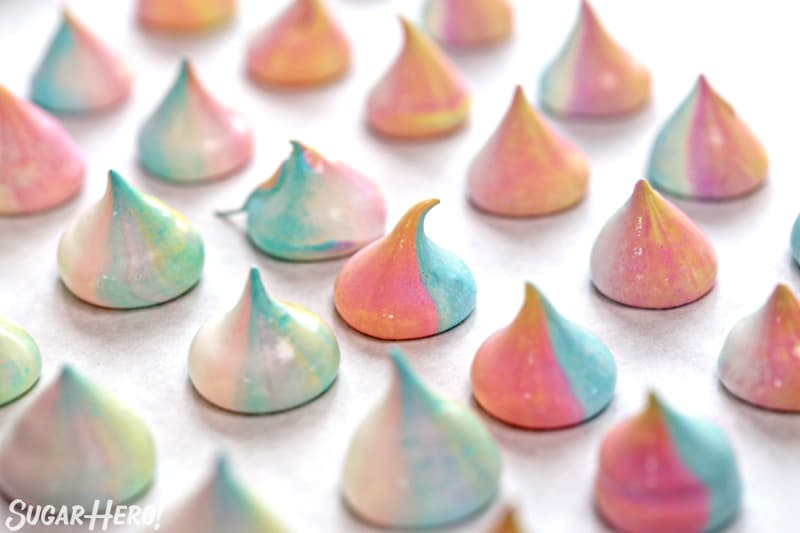 Multi-colored unicorn meringue cookies, piped on a baking sheet and ready to be baked