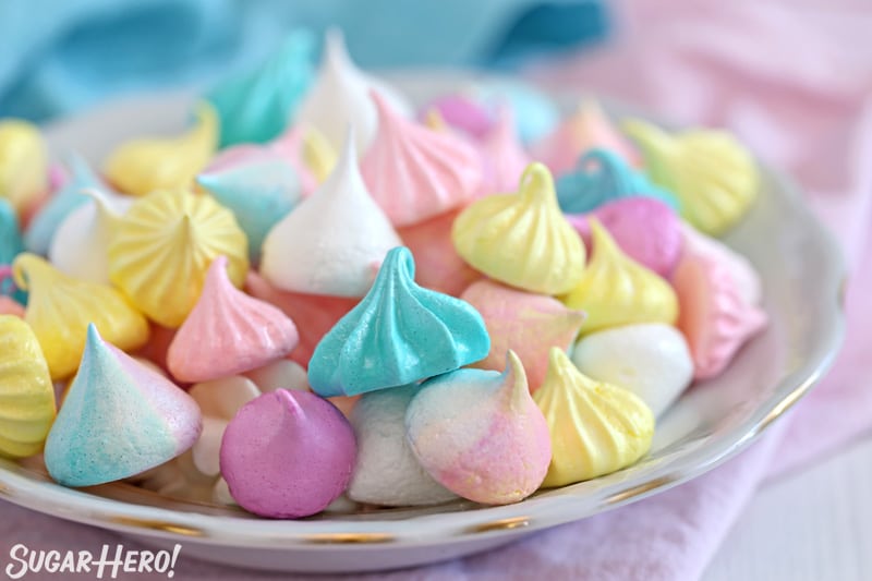 Colorful meringue cookies piled on top of each other on a plate
