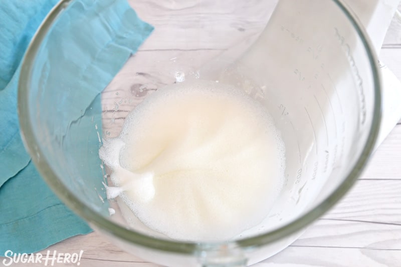 Foamy egg whites in glass mixing bowl
