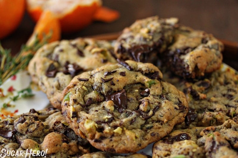 Clemen-Thyme Chocolate Chunk Cookies - Are soft, tender chocolate chunk cookies with clementine zest and a bit of fresh thyme. | From SugarHero.com Clemen-Thyme Chocolate Chunk Cookies - A stack of cookies displayed on a plate. | From SugarHero.com