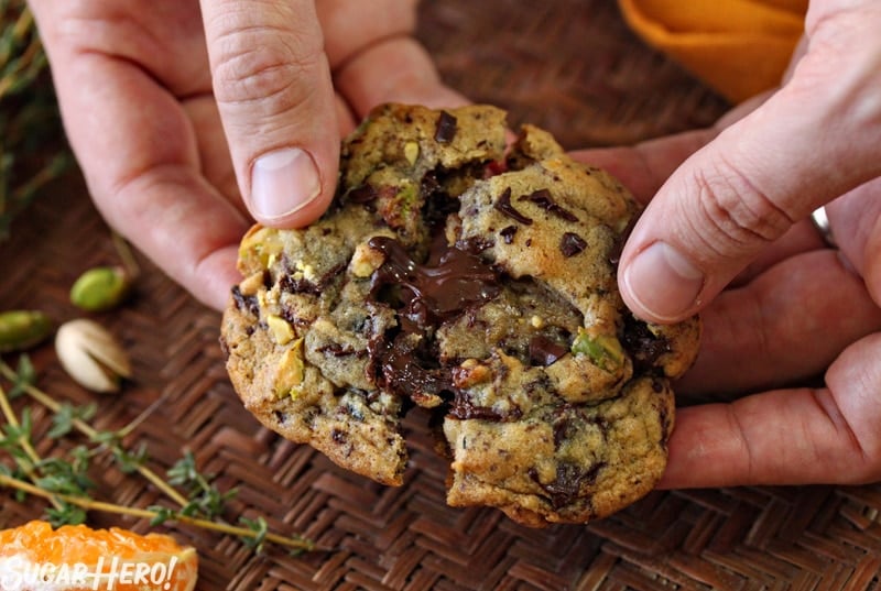 Clemen-Thyme Chocolate Chunk Cookies - Are soft, tender chocolate chunk cookies with clementine zest and a bit of fresh thyme. | From SugarHero.com Clemen-Thyme Chocolate Chunk Cookies - A shot of cookie being broken in half showing the inside chunks. | From SugarHero.com